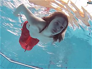 crimson clad teenage swimming with her eyes opened